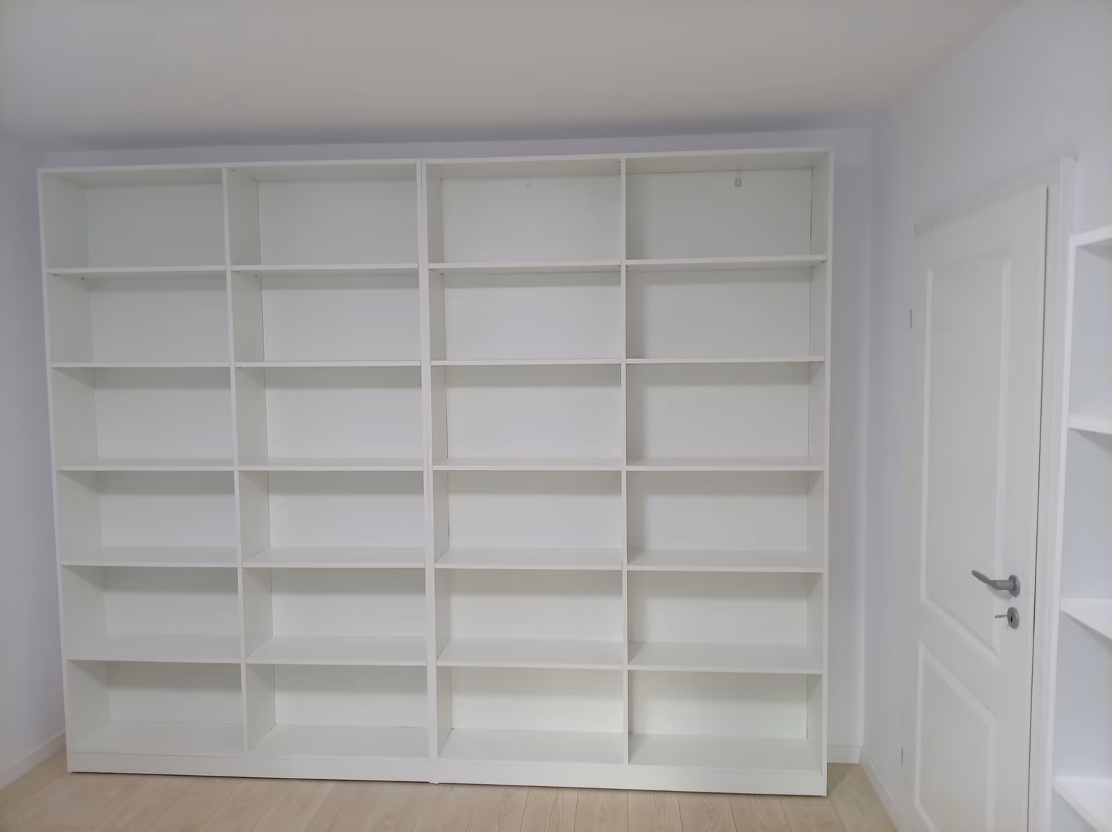 Bibliotecă albă la comandă în București, șase niveluri de rafturi pe toată lățimea peretelui